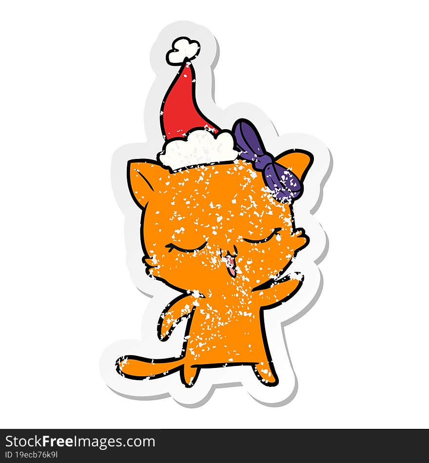 distressed sticker cartoon of a cat with bow on head wearing santa hat