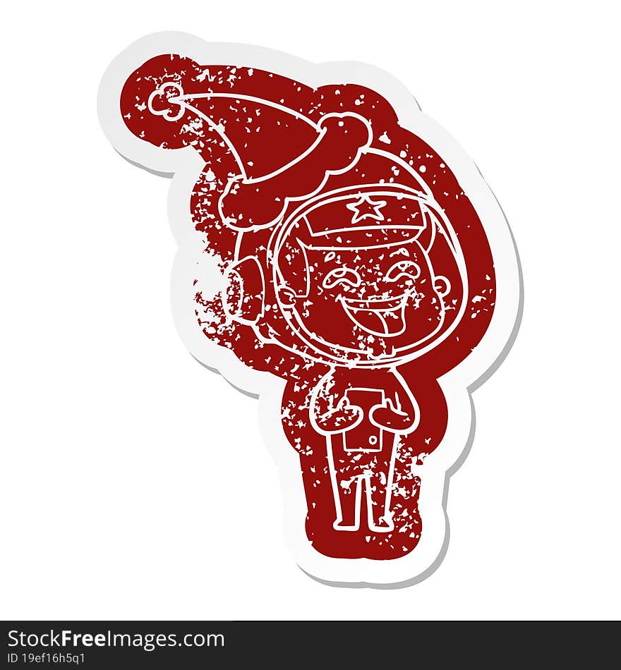 cartoon distressed sticker of a laughing astronaut wearing santa hat