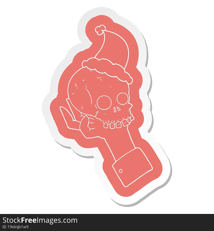 cartoon  sticker of a hand holding skull wearing santa hat