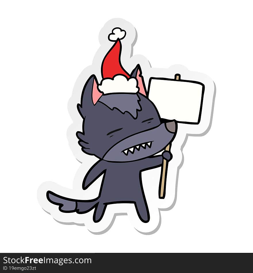 Sticker Cartoon Of A Wolf With Sign Post Showing Teeth Wearing Santa Hat