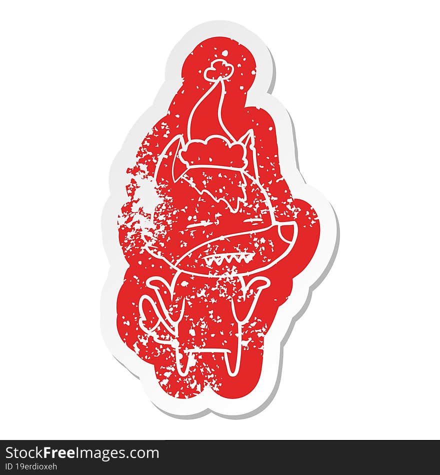 cartoon distressed sticker of a wolf showing teeth wearing santa hat