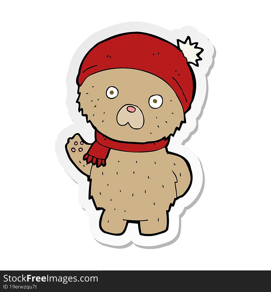 sticker of a cartoon teddy bear in winter hat and scarf