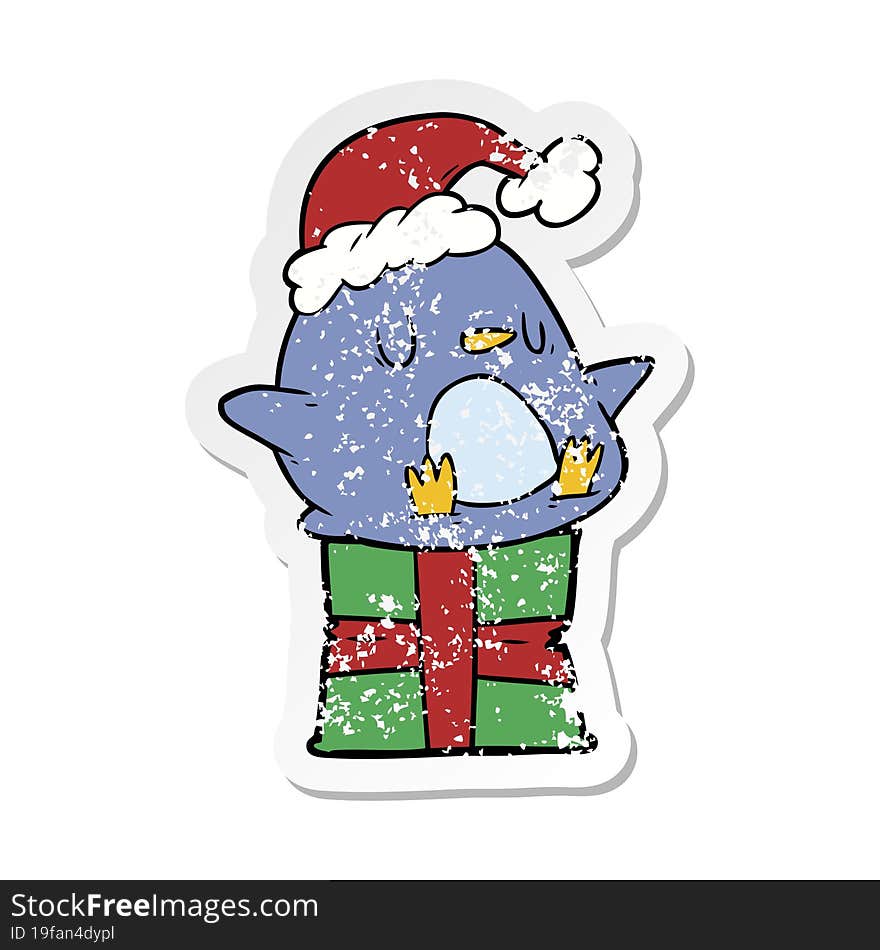 distressed sticker of a cute cartoon penguin sitting on gift