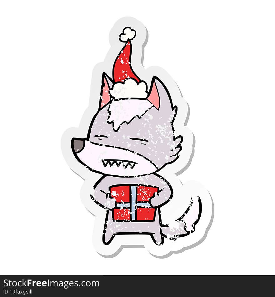 distressed sticker cartoon of a wolf with a gift wearing santa hat