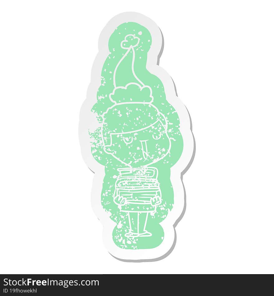 quirky cartoon distressed sticker of a happy boy with stack of books wearing santa hat