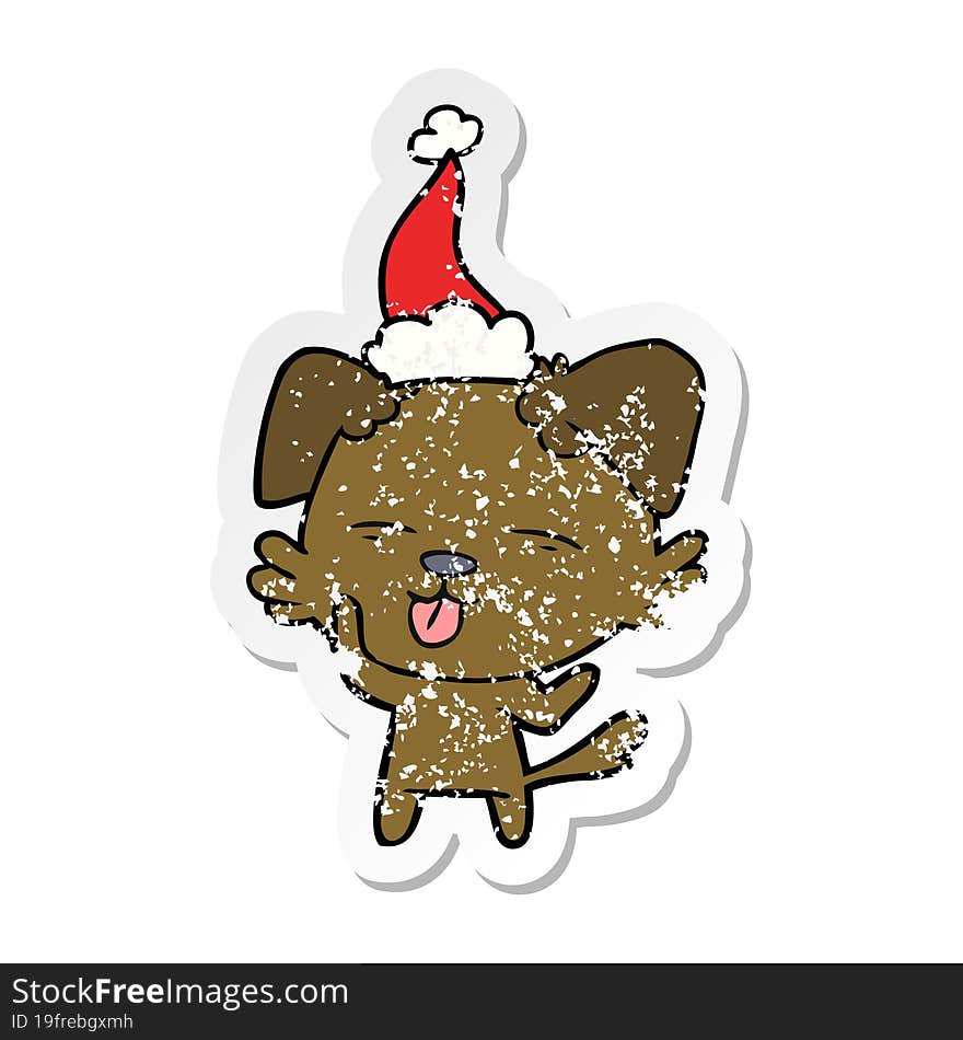 distressed sticker cartoon of a dog sticking out tongue wearing santa hat