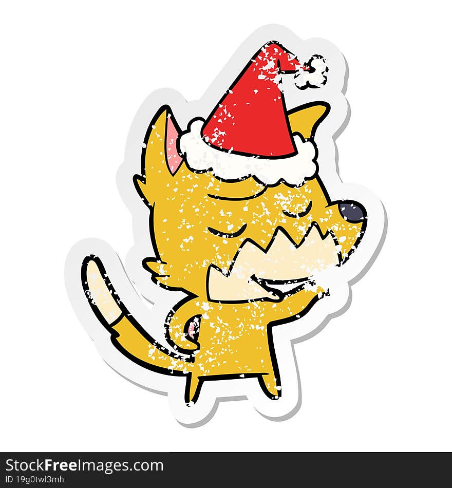 friendly distressed sticker cartoon of a fox wearing santa hat