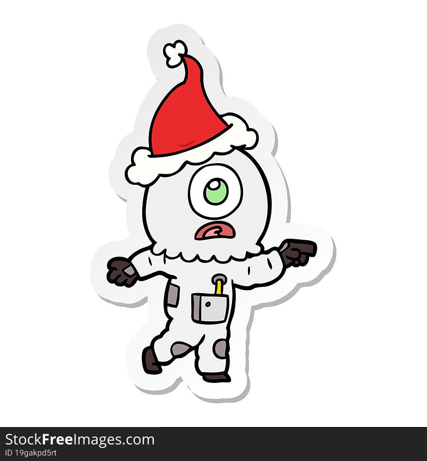 hand drawn sticker cartoon of a cyclops alien spaceman pointing wearing santa hat