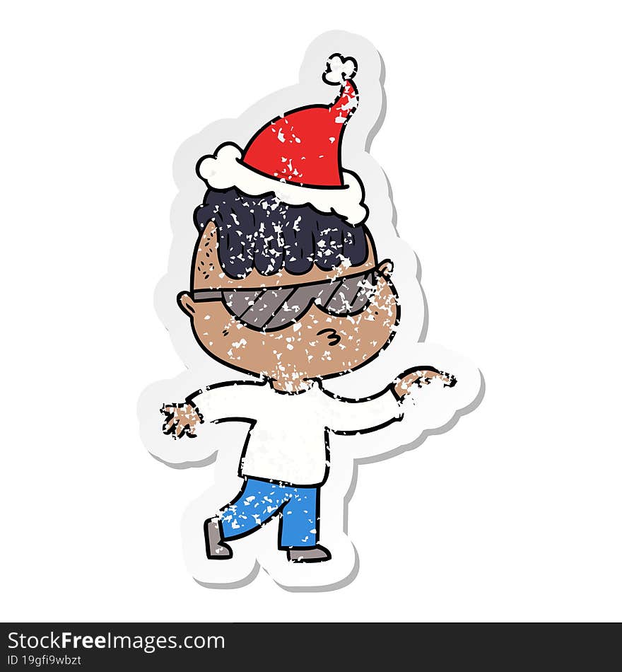 hand drawn distressed sticker cartoon of a boy wearing sunglasses pointing wearing santa hat