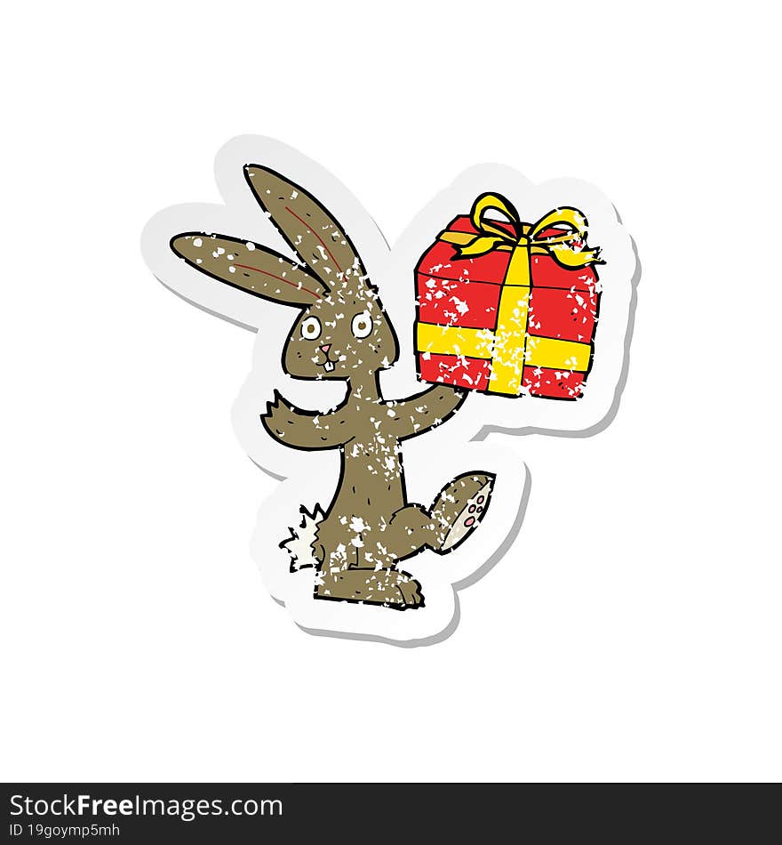 Retro Distressed Sticker Of A Cartoon Rabbit With Christmas Present