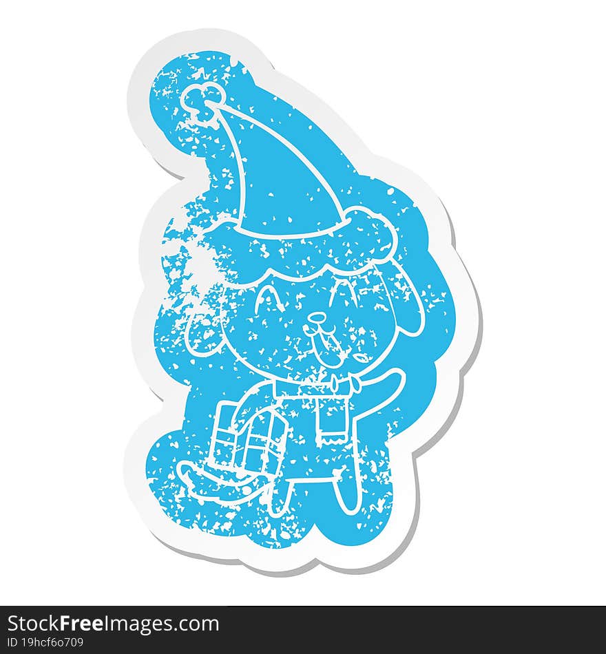 cute quirky cartoon distressed sticker of a dog with christmas present wearing santa hat