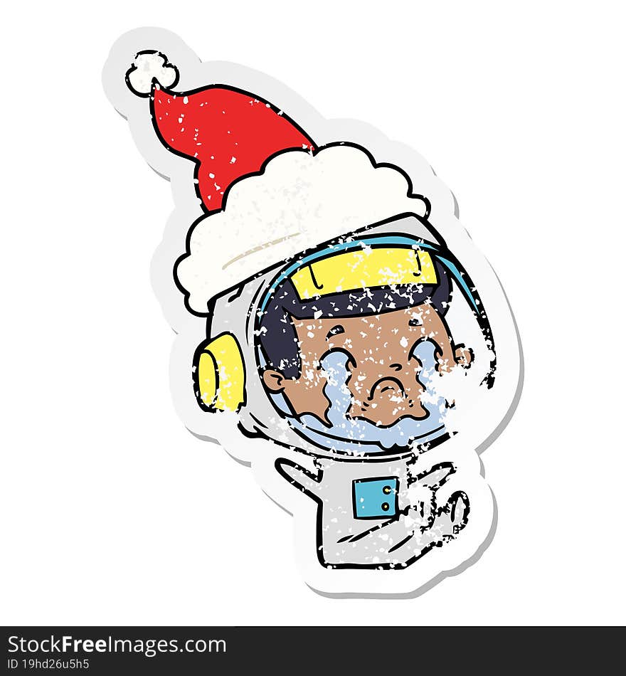 distressed sticker cartoon of a crying astronaut wearing santa hat