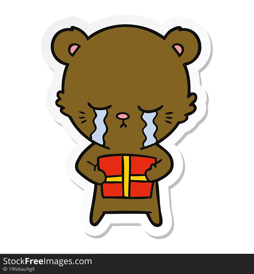 sticker of a crying cartoon bear with present