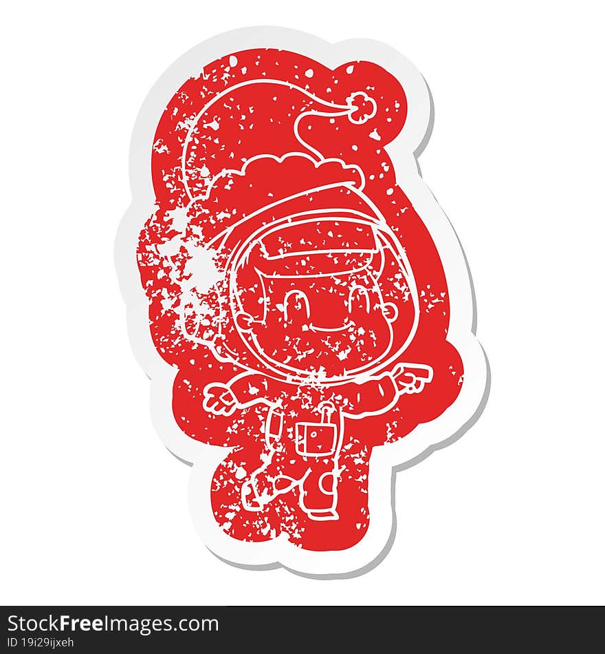 happy cartoon distressed sticker of a astronaut man wearing santa hat