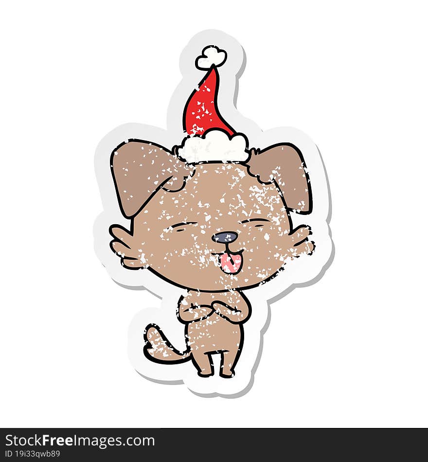 distressed sticker cartoon of a dog sticking out tongue wearing santa hat