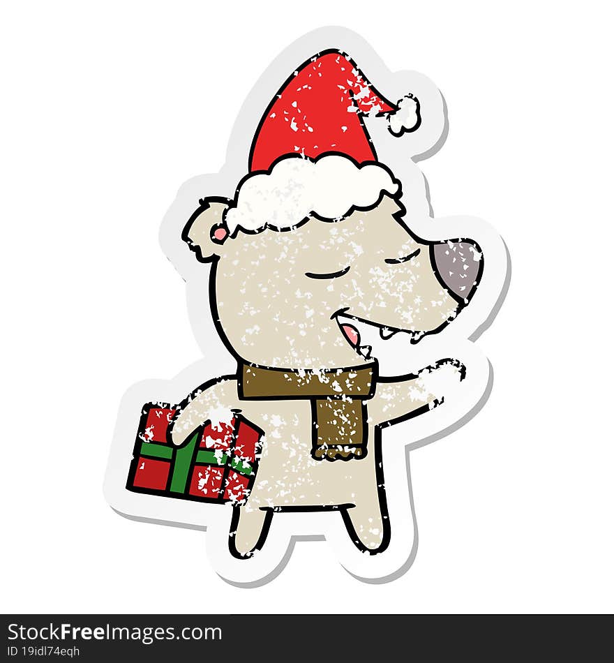 distressed sticker cartoon of a bear with present wearing santa hat