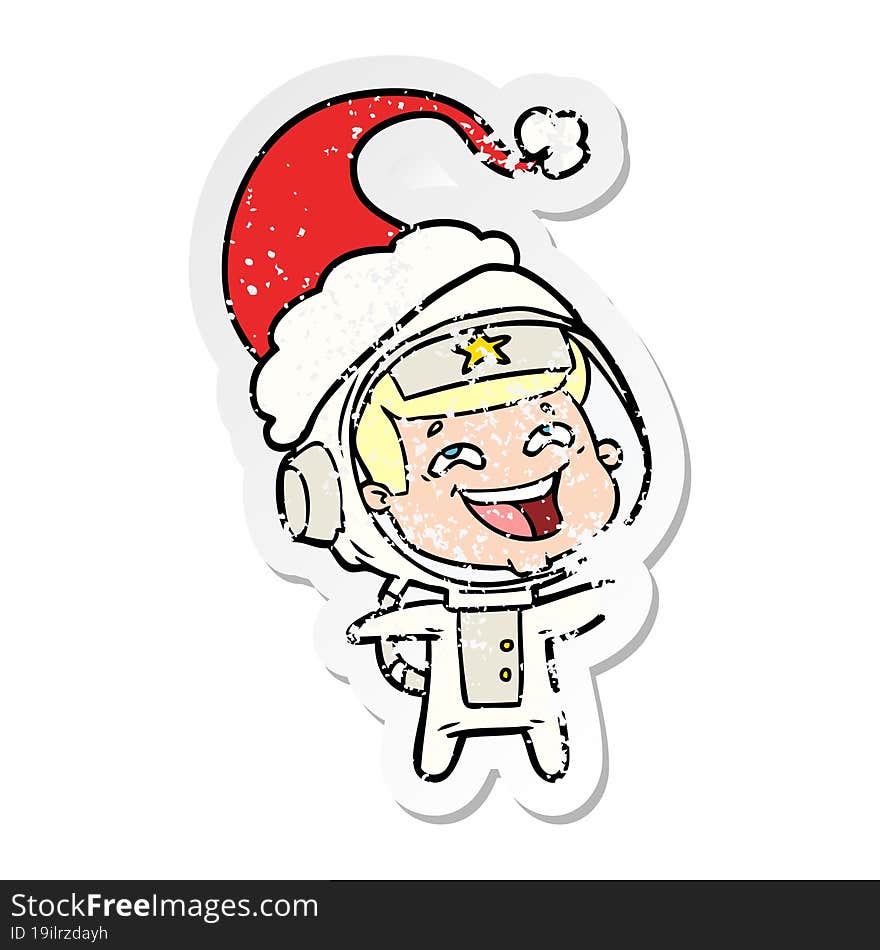 distressed sticker cartoon of a laughing astronaut wearing santa hat