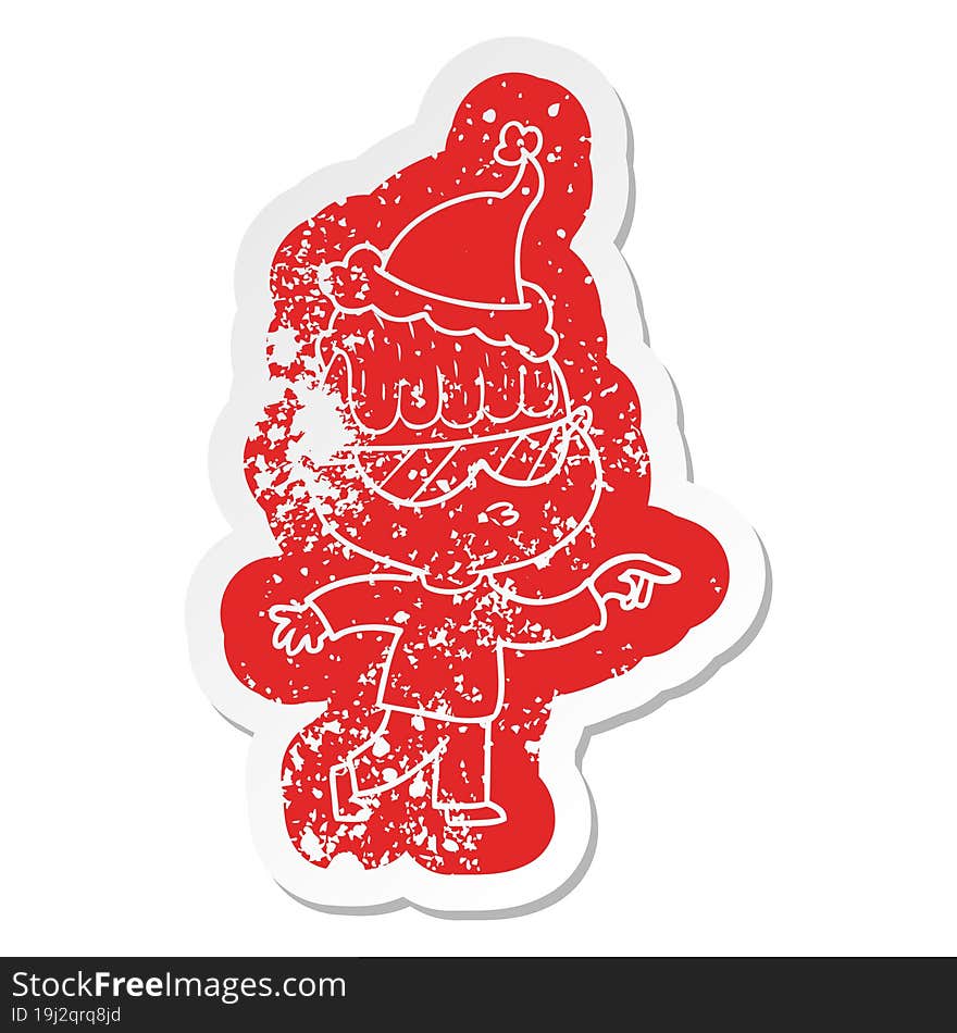 cartoon distressed sticker of a boy wearing sunglasses pointing wearing santa hat