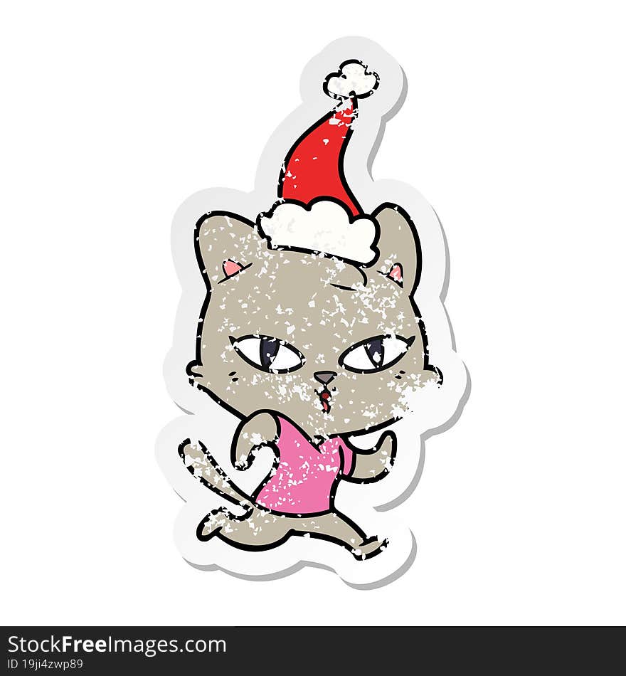 hand drawn distressed sticker cartoon of a cat out for a run wearing santa hat