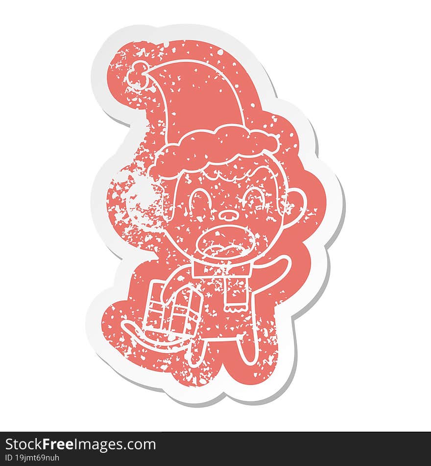 shouting cartoon distressed sticker of a monkey carrying christmas gift wearing santa hat