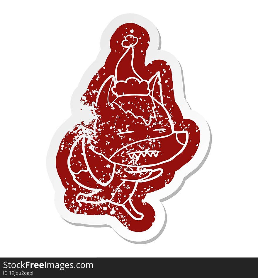 quirky cartoon distressed sticker of a wolf showing teeth wearing santa hat