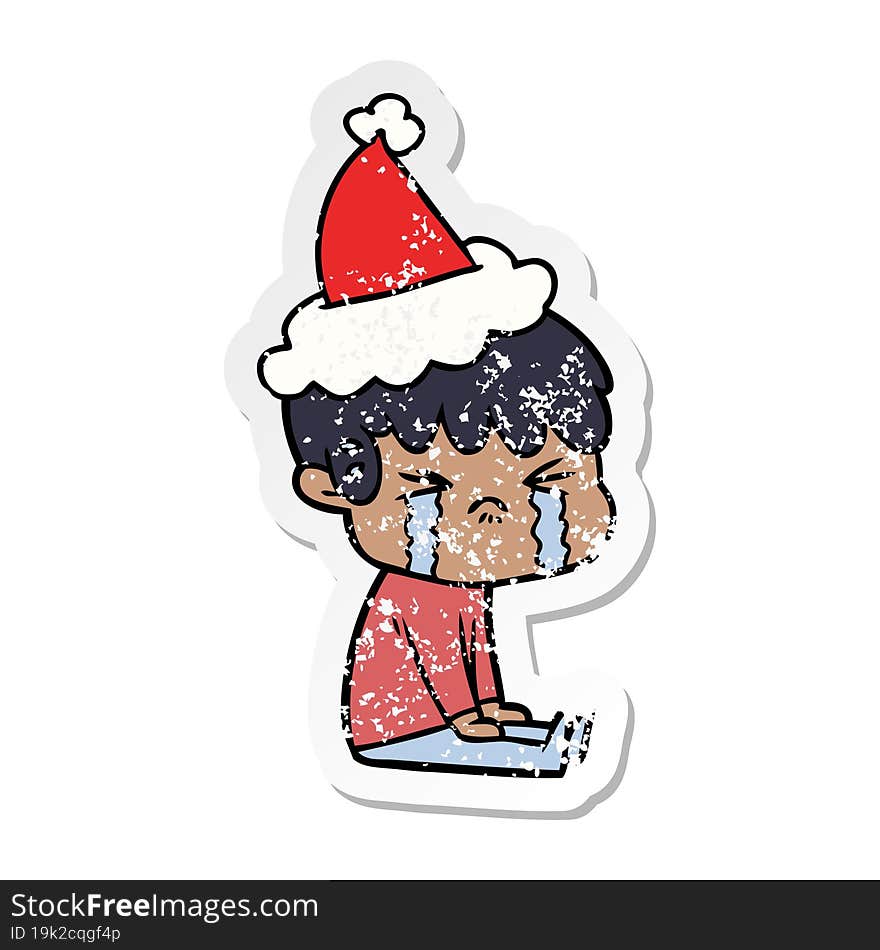 Distressed Sticker Cartoon Of A Boy Crying Wearing Santa Hat