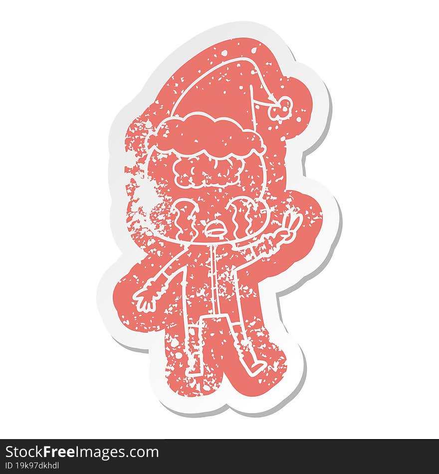 cartoon distressed sticker of a big brain alien crying and giving peace sign wearing santa hat