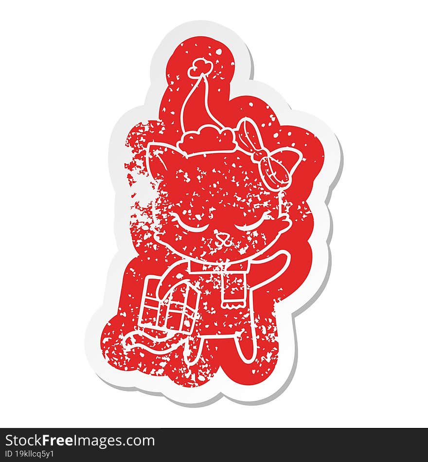 cute cartoon distressed sticker of a cat with present wearing santa hat