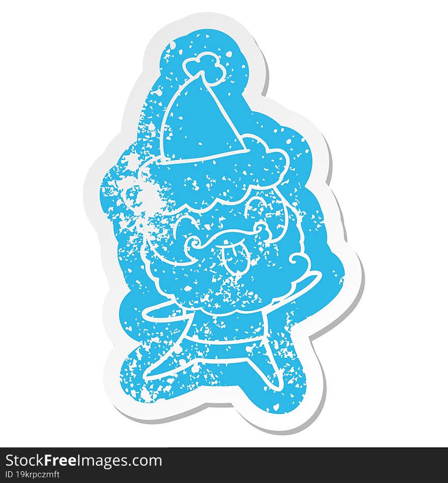 distressed sticker of a man with beard sticking out tongue wearing santa hat