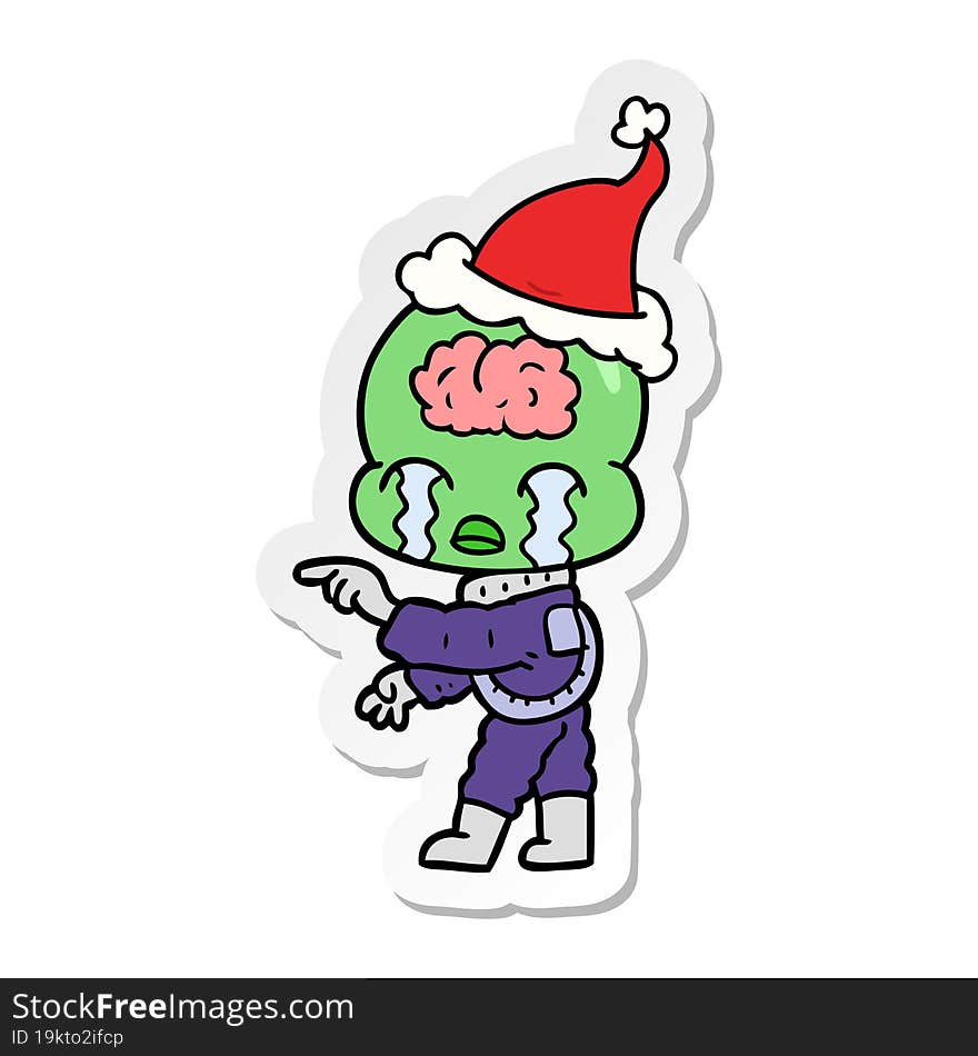 sticker cartoon of a big brain alien crying and pointing wearing santa hat