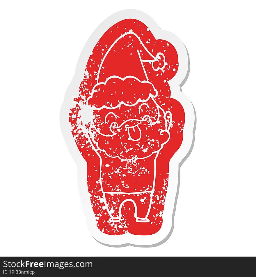 Distressed sticker featuring man with beard sticking out tongue wearing santa hat