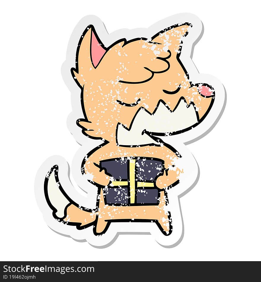 distressed sticker of a friendly cartoon fox with christmas present