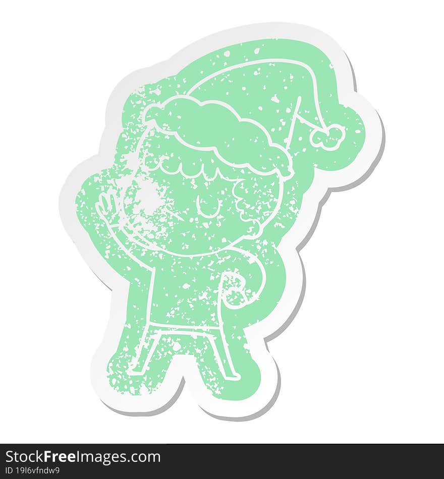 cartoon distressed sticker of a grumpy boy wearing santa hat