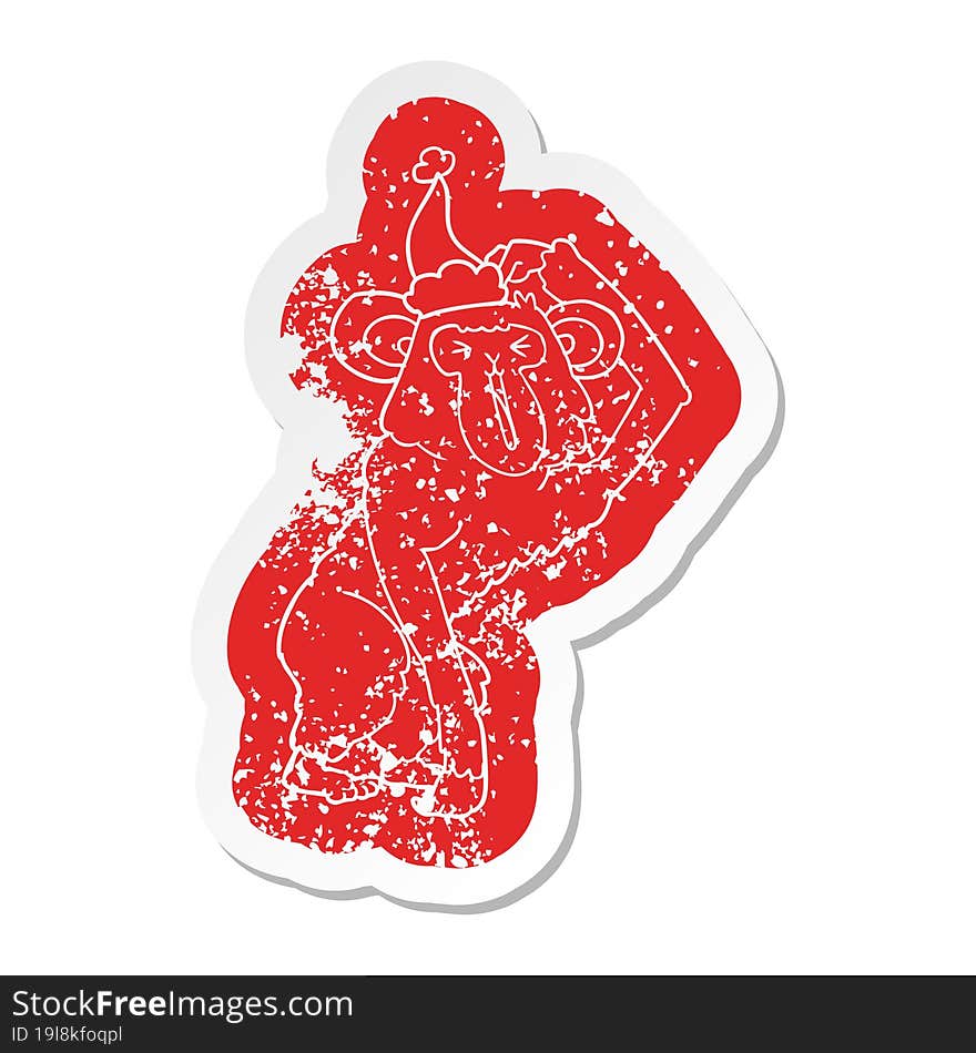 cartoon distressed sticker of a chimp scratching head wearing santa hat