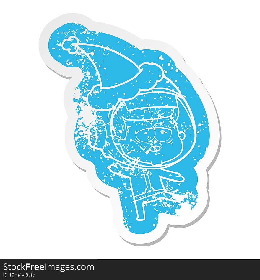 Cartoon Distressed Sticker Of A Tired Astronaut Wearing Santa Hat