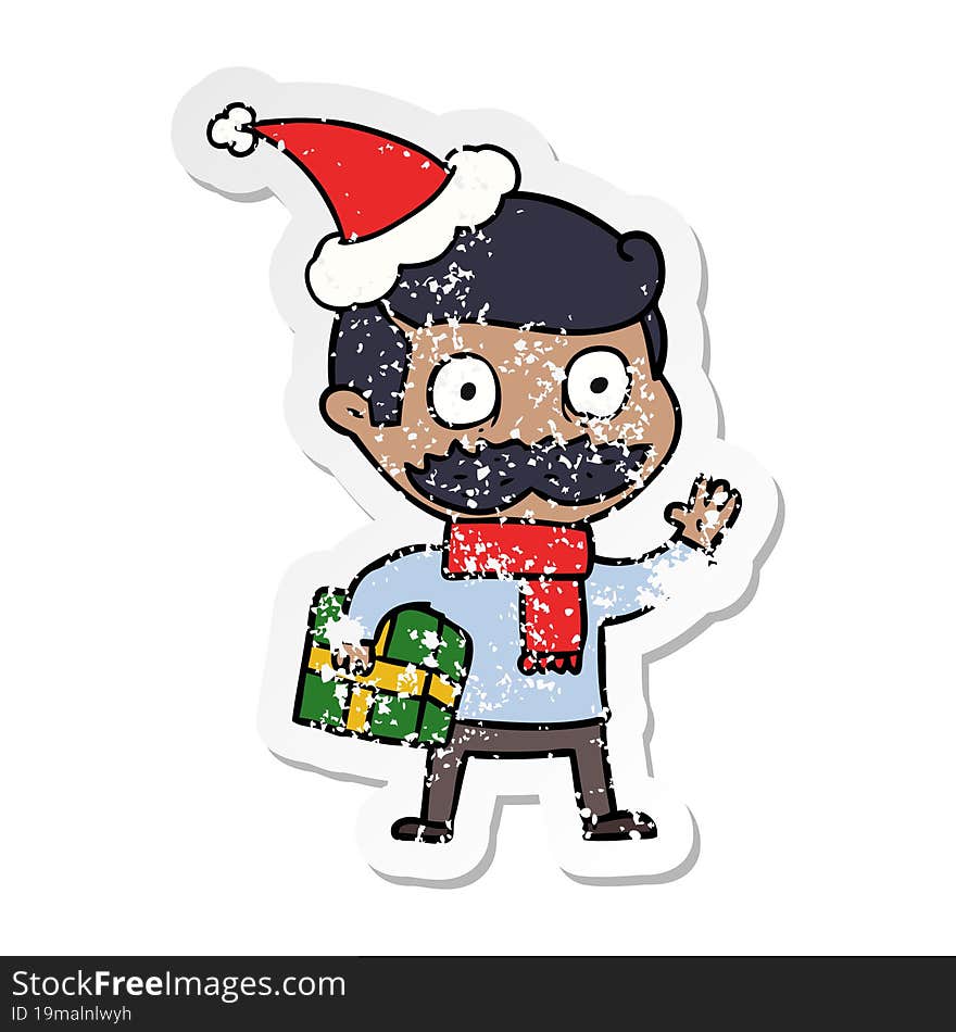 distressed sticker cartoon of a man with mustache and christmas present wearing santa hat