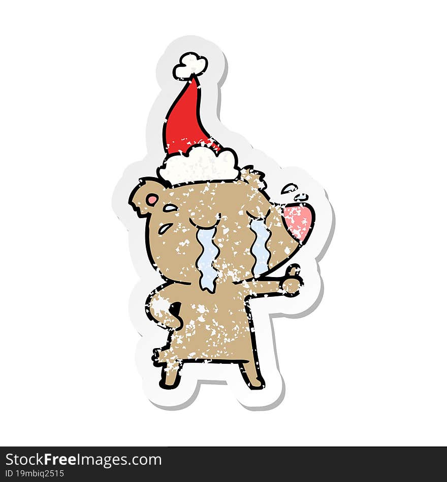 hand drawn distressed sticker cartoon of a crying bear wearing santa hat