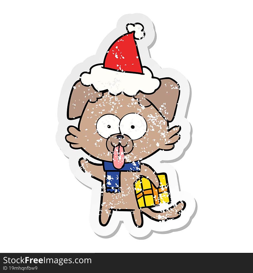 hand drawn distressed sticker cartoon of a dog with christmas present wearing santa hat