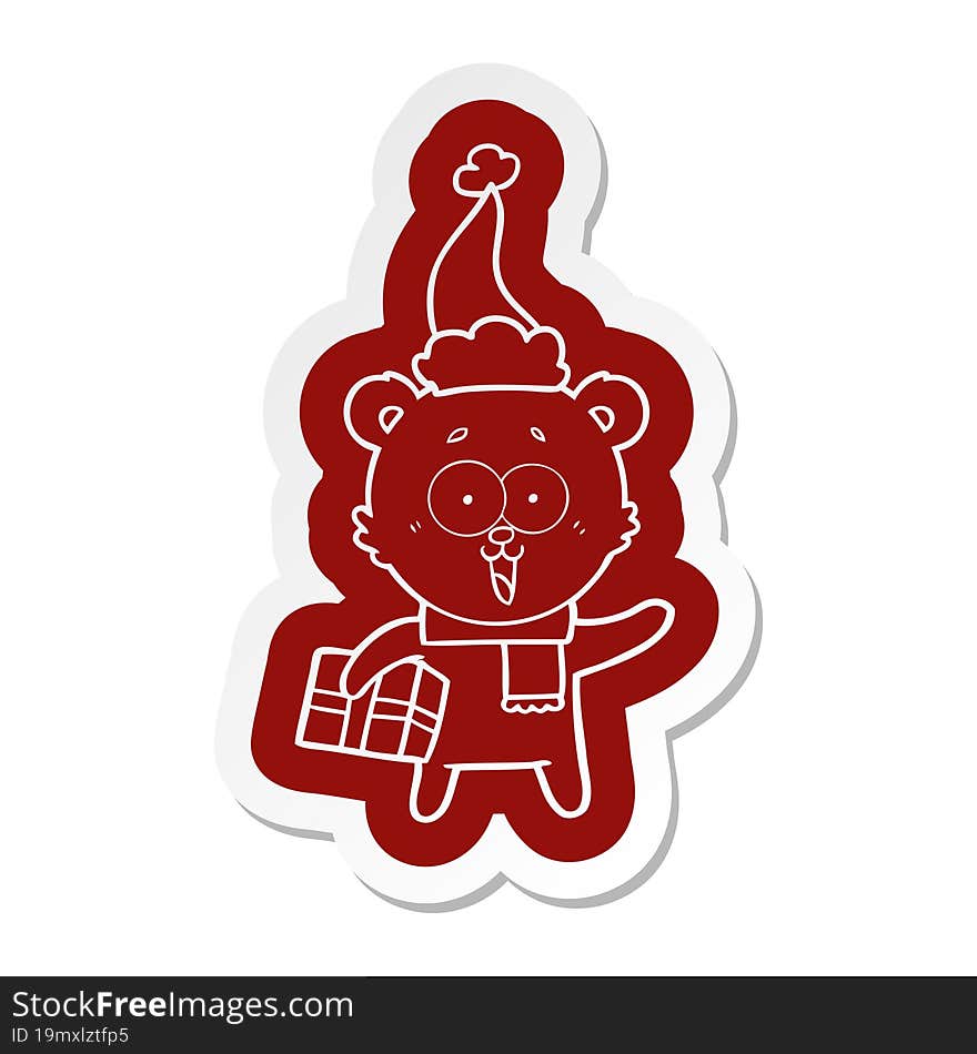 laughing teddy  bear with christmas present wearing santa hat