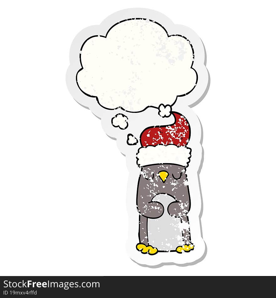 cartoon christmas penguin and thought bubble as a distressed worn sticker