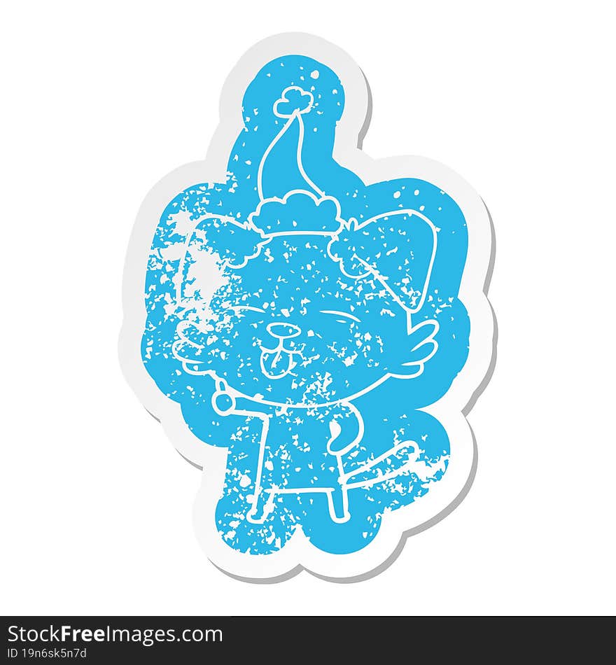 quirky cartoon distressed sticker of a dog sticking out tongue wearing santa hat