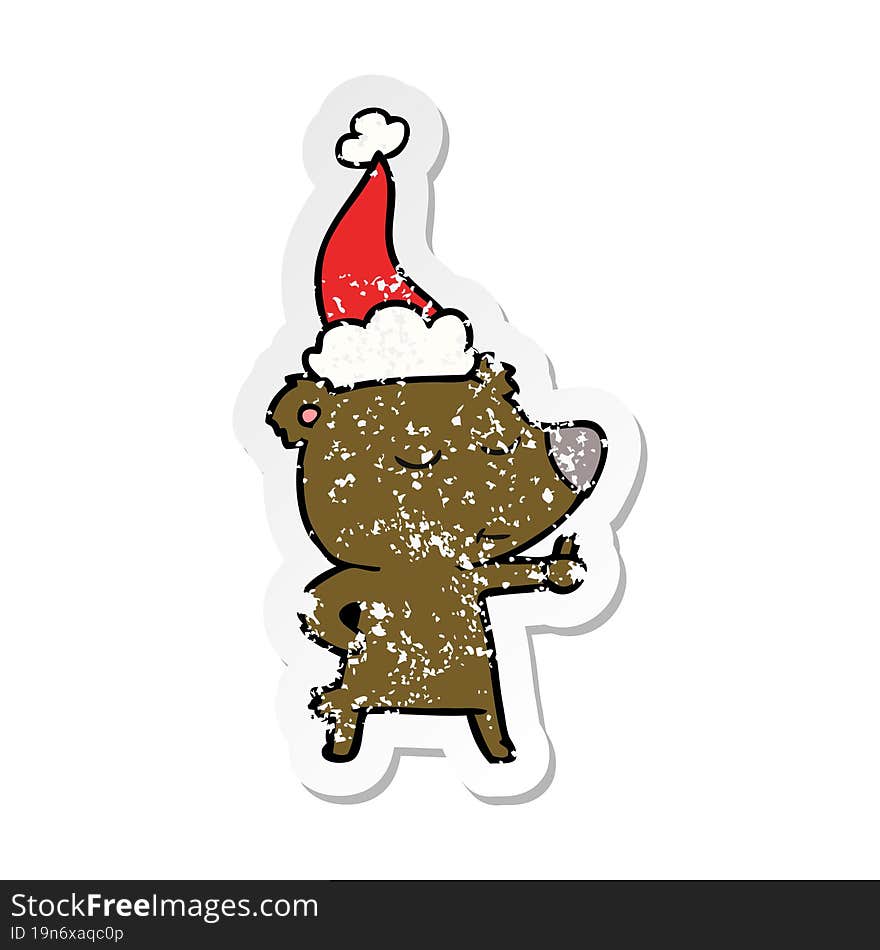 happy hand drawn distressed sticker cartoon of a bear giving thumbs up wearing santa hat