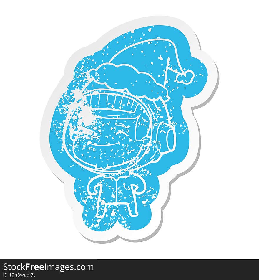 happy quirky cartoon distressed sticker of a astronaut wearing santa hat