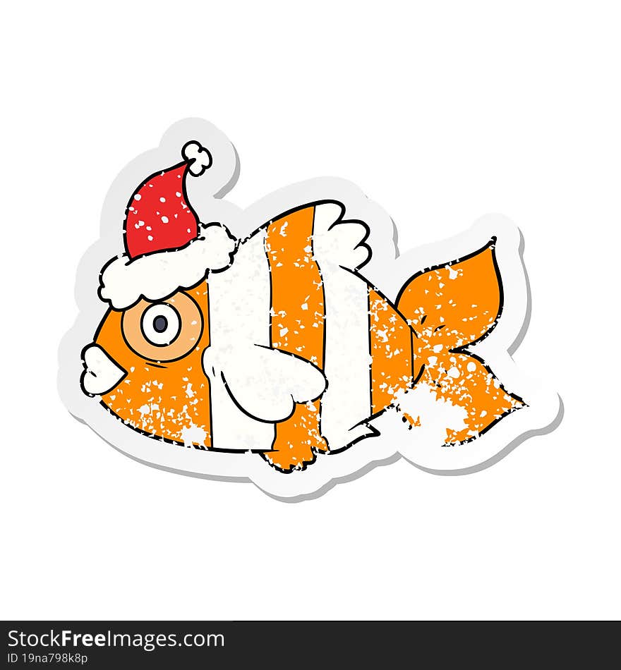 distressed sticker cartoon of a exotic fish wearing santa hat