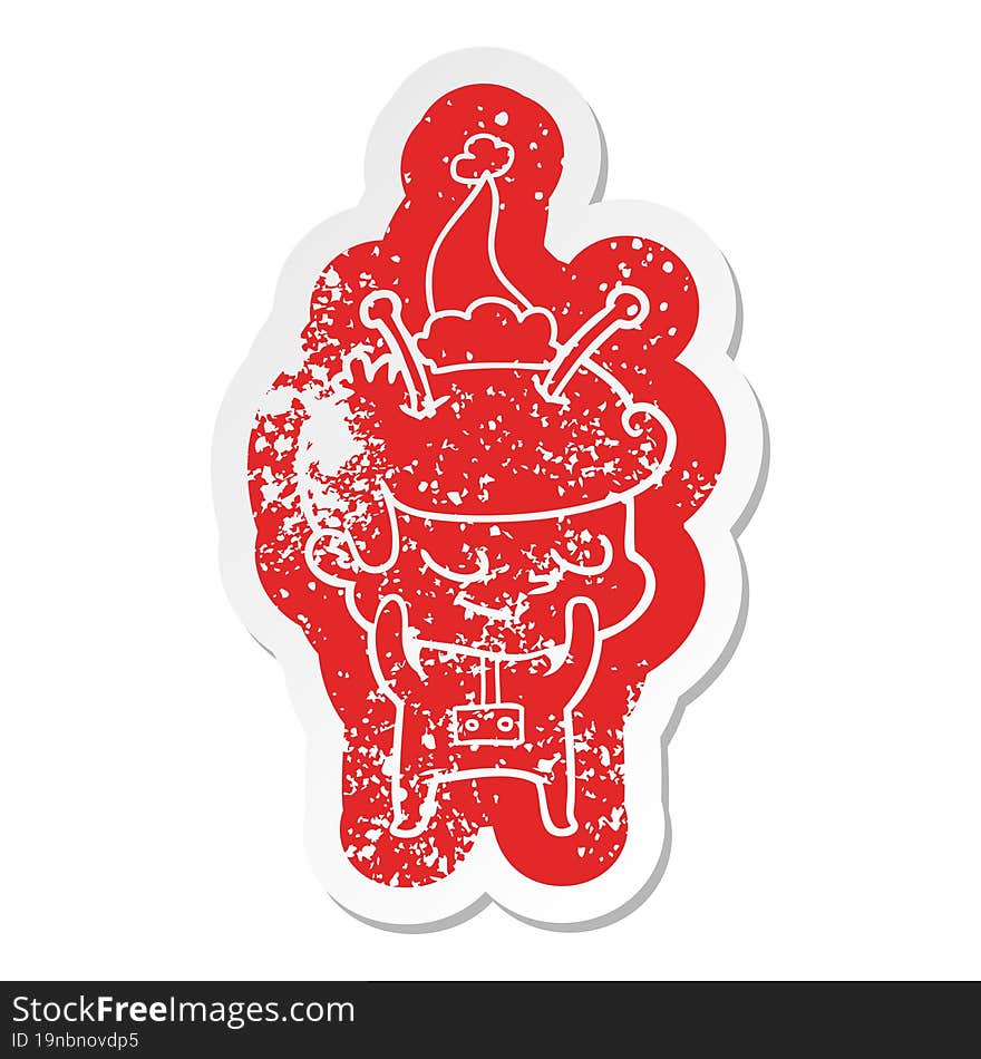 shy quirky cartoon distressed sticker of a spaceman wearing santa hat