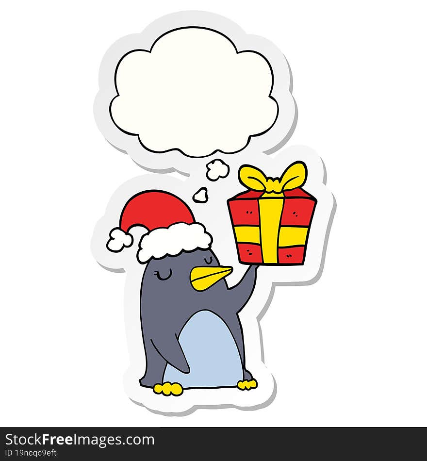 cartoon penguin with christmas present and thought bubble as a printed sticker