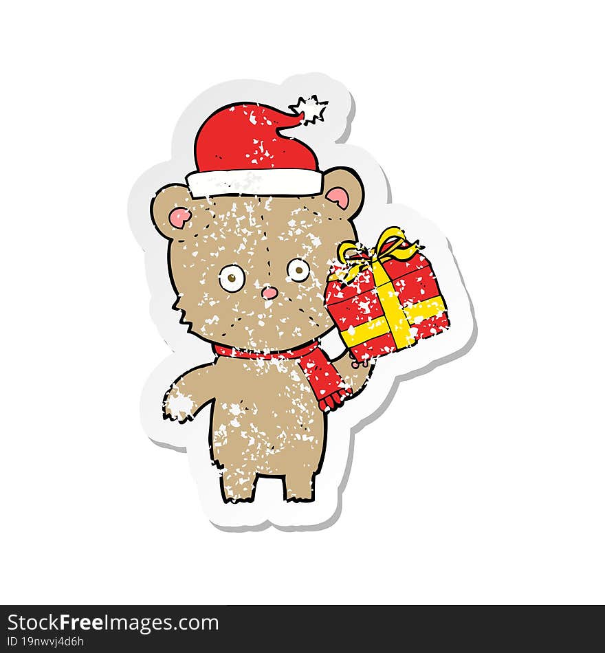 retro distressed sticker of a cartoon christmas teddy bear with present