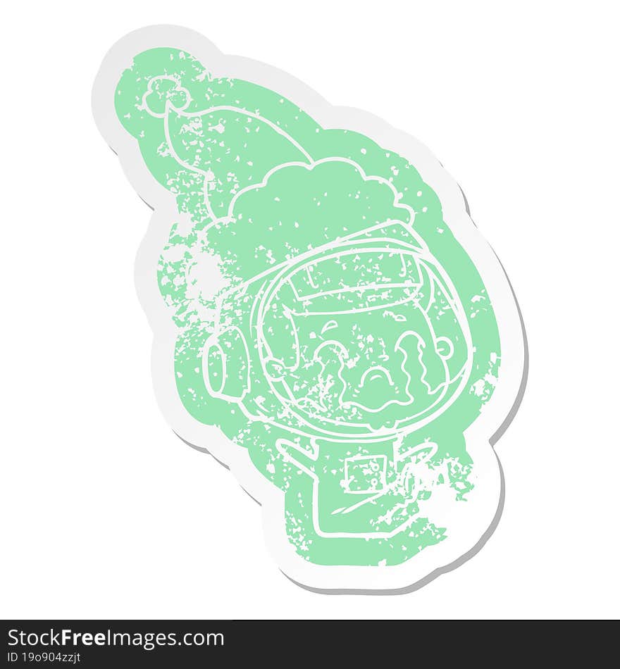 cartoon distressed sticker of a crying astronaut wearing santa hat