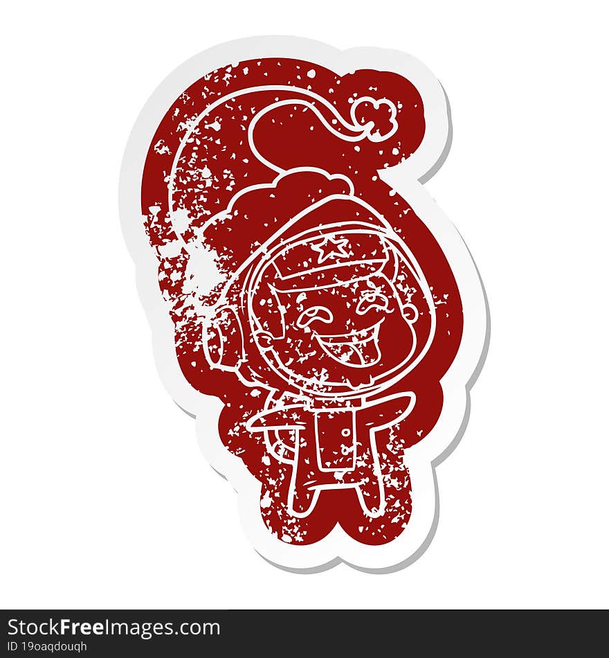 cartoon distressed sticker of a laughing astronaut wearing santa hat