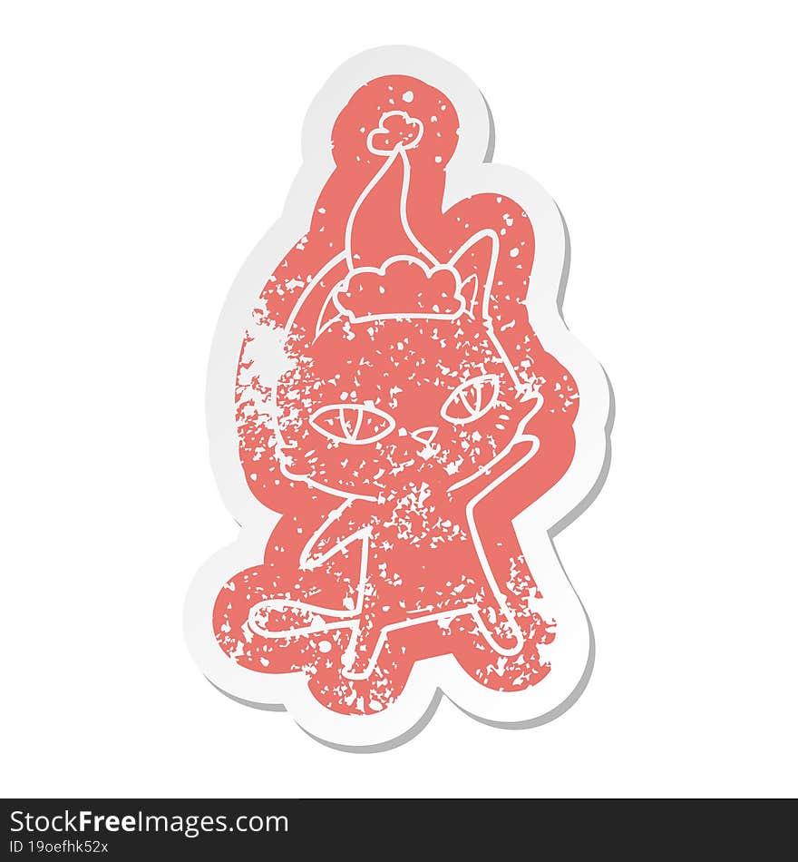 cartoon distressed sticker of a cat staring wearing santa hat